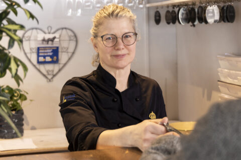 Kvinna står i en reception och räcker över en nyckel till en gäst