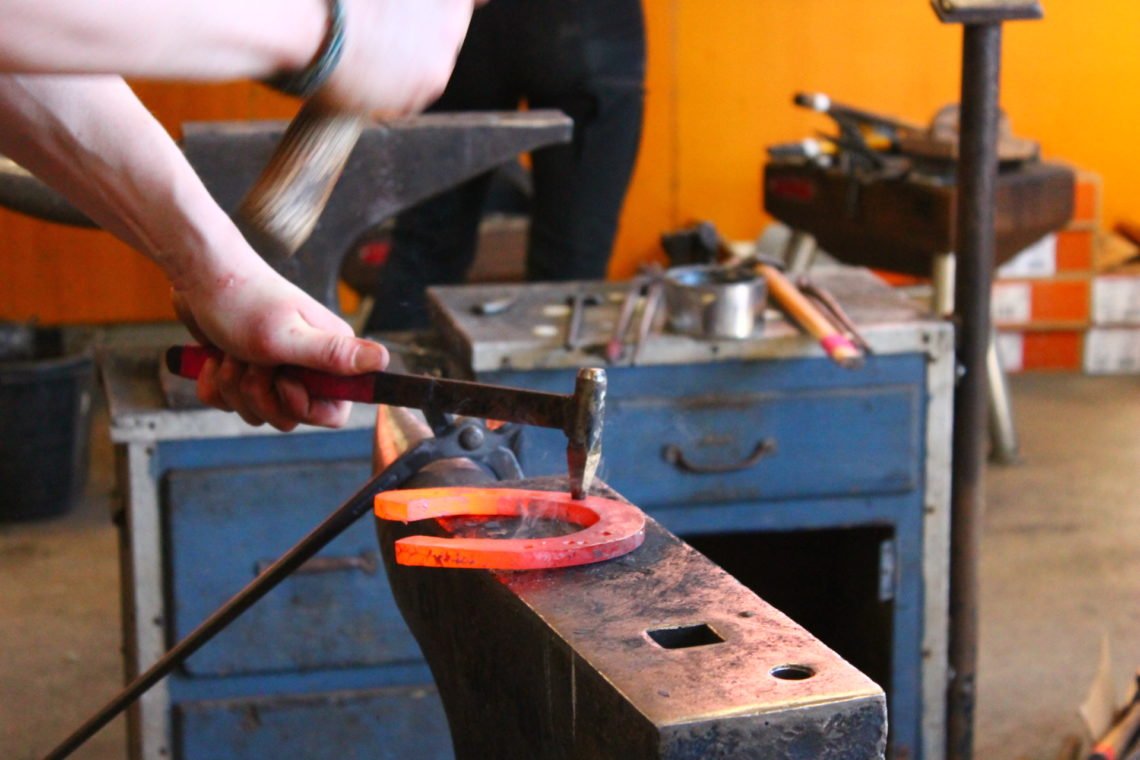 Varmskoning pågår. Här syns en glödgad hästsko på ett städ